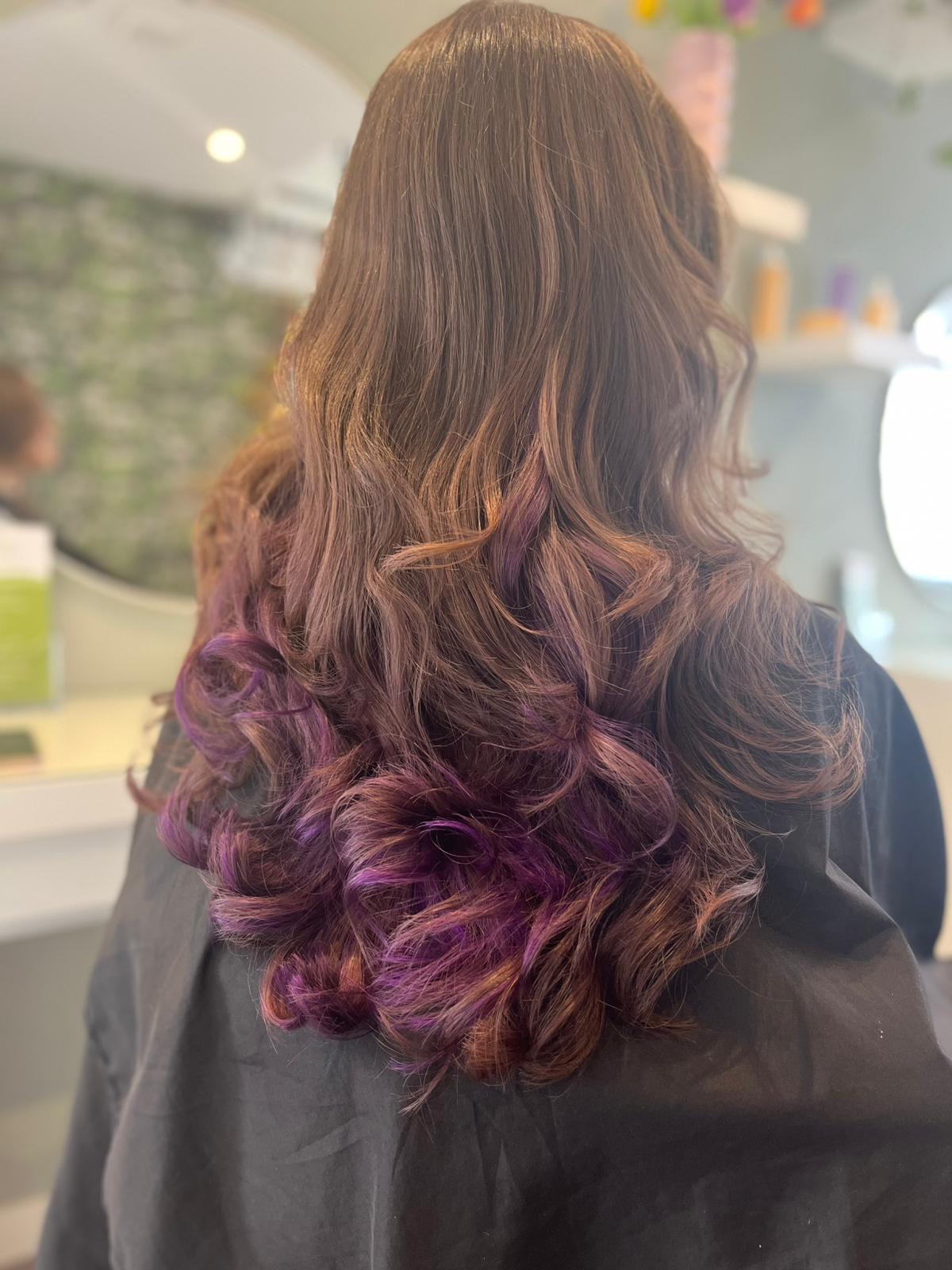Bruin haar met paarse uiteinden in krullen, van achteren in de salon